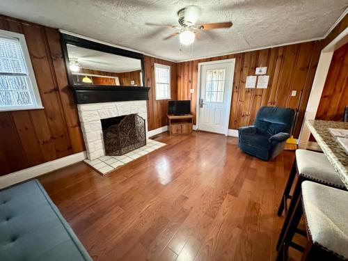 a living room with a fireplace and wooden walls at Cottage 6- Lees Ford Marina in Nancy