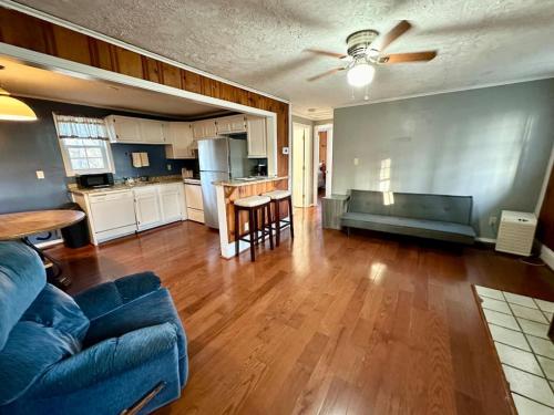 a living room with a blue couch and a kitchen at Cottage 6- Lees Ford Marina in Nancy