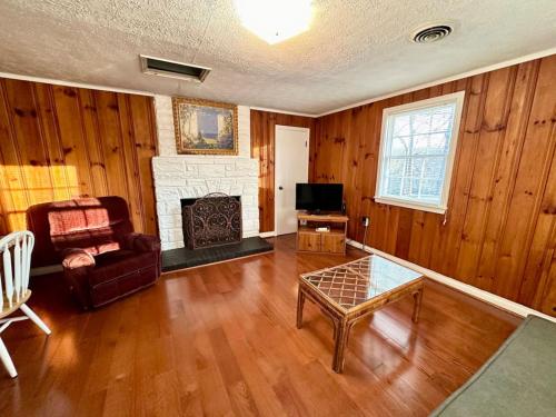sala de estar con paneles de madera y chimenea en Cottage 5- Lees Ford Marina, en Nancy
