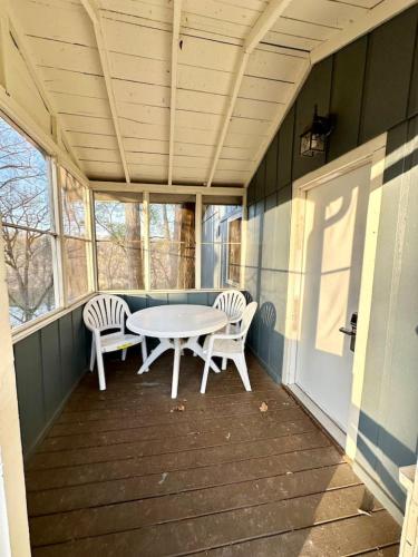 a porch with a table and two chairs on it at Cottage 5- Lees Ford Marina in Nancy