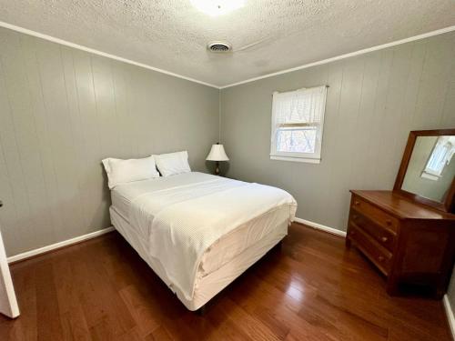 ein Schlafzimmer mit einem großen weißen Bett und einer Kommode in der Unterkunft Cottage 5- Lees Ford Marina in Nancy