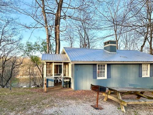 ein blaues Haus mit einem Picknicktisch davor in der Unterkunft Cottage 5- Lees Ford Marina in Nancy
