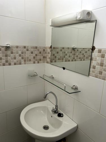 a bathroom with a sink and a mirror at Chambre spacieuse climatisée - SDB privée & Cuisine équipée & Breakfast in Saint-Louis