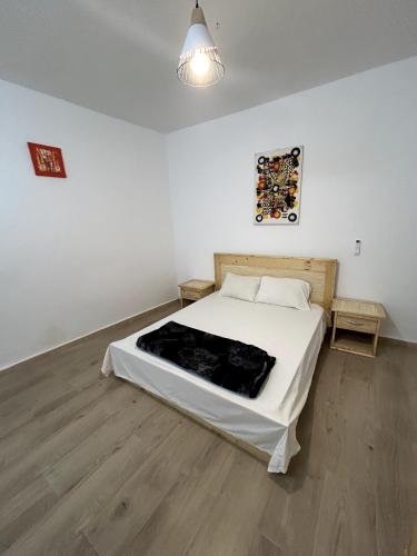 a bedroom with a bed in a white room at Chambre spacieuse climatisée - SDB privée & Cuisine équipée & Breakfast in Saint-Louis