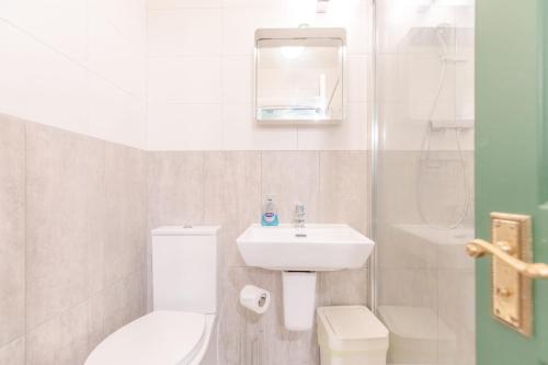 a white bathroom with a sink and a toilet at Bright 3 Bedroom House Near King's Cross StPancras in London