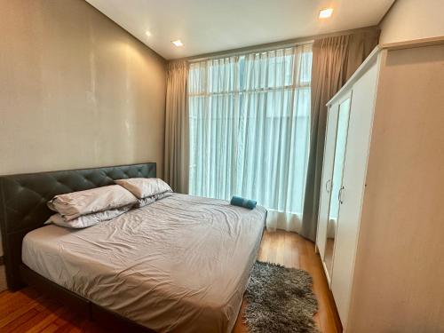a bedroom with a bed and a large window at 2bedroom soho suites klcc in Kuala Lumpur