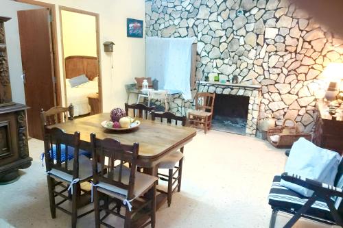 a dining room with a table and a stone wall at 3 bedrooms house with enclosed garden at Simat de la Valldigna in Bárig
