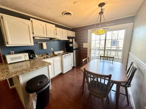 a kitchen with a wooden table and a dining room at Cottage 10 Lees Ford Marina in Nancy