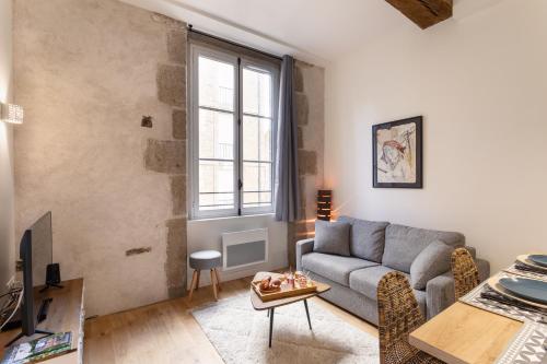 un salon avec un canapé et une fenêtre dans l'établissement Le Kodama - Appt en plein coeur de St Malo, à Saint-Malo