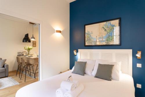 une chambre avec un lit blanc avec un mur bleu dans l'établissement Le Kodama - Appt en plein coeur de St Malo, à Saint-Malo