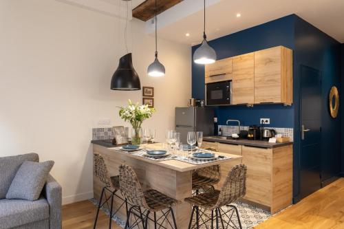une cuisine avec une table et des chaises dans une pièce dans l'établissement Le Kodama - Appt en plein coeur de St Malo, à Saint-Malo