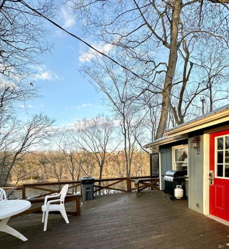 a deck with a table and chairs and a house at Cottage 2 Lees Ford Marina in Nancy