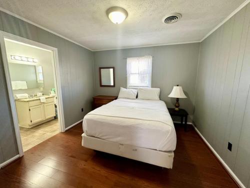 1 Schlafzimmer mit einem weißen Bett und einem Badezimmer in der Unterkunft Cottage 7 Lees Ford Marina in Nancy