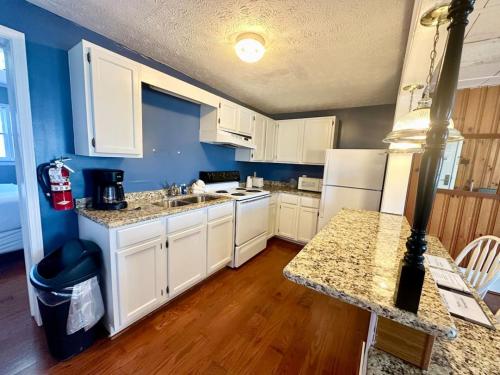 a kitchen with white cabinets and a counter top at Cottage 8Lees Ford Marina in Nancy