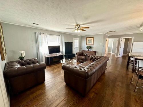 a living room with two leather couches and a television at Cottage 17- Lees Ford Marina in Nancy