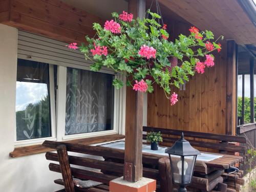 een veranda met een tafel met bloemen erop bij domek letniskowy in Małe Swornigacie