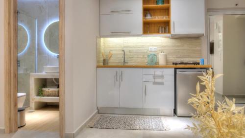 a kitchen with white cabinets and a sink at Loutsiana Apartments Corfu in Alykes Potamou
