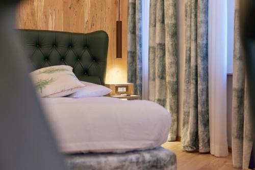 a bedroom with a bed with a green headboard at Dolada Boutique Hotel in Staol