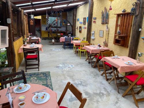 um restaurante com mesas e cadeiras cor-de-rosa num quarto em Pousada Jardim Secreto em Teresópolis