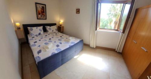 a bedroom with a bed with blue and white sheets and a window at Apartman Linda in Milna