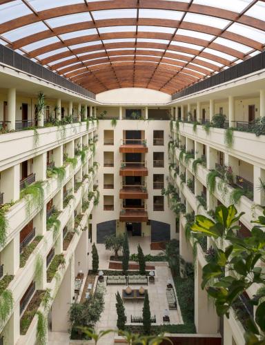 an indoor courtyard of a building with plants at Puerto Antilla Grand Hotel in Islantilla