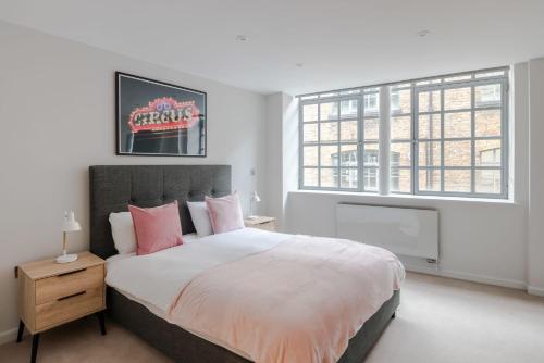 ein Schlafzimmer mit einem großen Bett mit rosa Kissen in der Unterkunft Circus of Colour - Farringdon - by Frankie Says in London