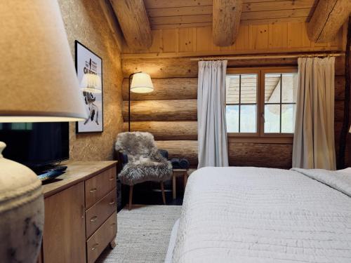 a bedroom with a bed and a chair and a window at 0 Simple - The Heiti Lodge in Gsteig