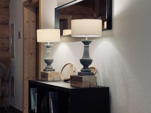two lamps on a table in a room with a mirror at 0 Simple - The Heiti Lodge in Gsteig