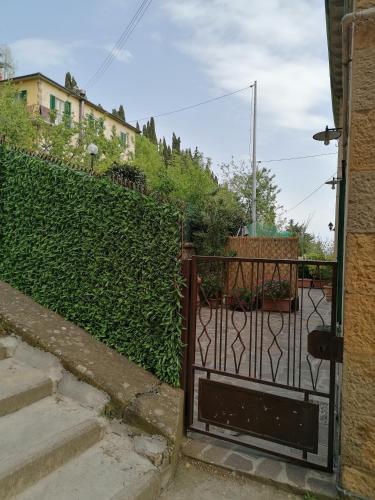 an open gate in front of a green hedge at appartamento Papaveri di Casa Mosaico in Volterra