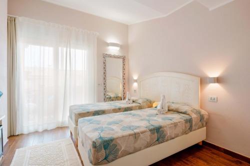 a bedroom with two beds and a large window at La rosa dei venti in Villasimius
