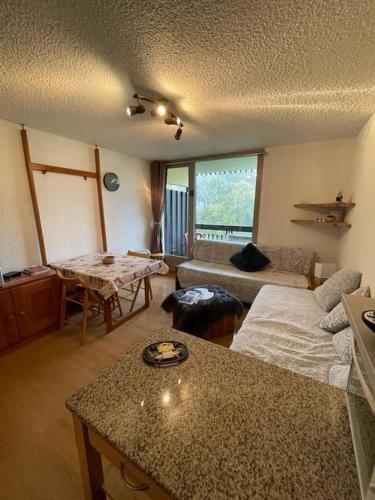 a living room with a couch and a table at Appart à la montagne in Arâches-la-Frasse