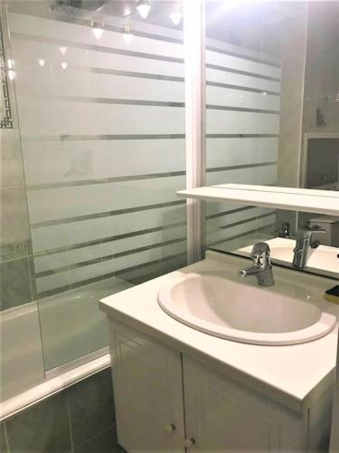 une salle de bain blanche avec un lavabo et une douche dans l'établissement Appart à la montagne navette et parking gratuit, à Arâches-la-Frasse