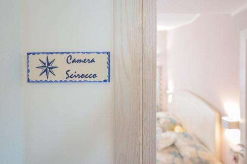 a sign on a wall next to a crib at La rosa dei venti in Villasimius
