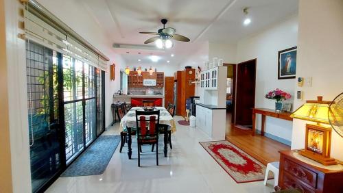 a dining room with a table and a kitchen at Liturs house in Bacolod