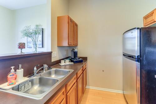 a kitchen with a sink and a refrigerator at Michigan Townhome with Smart TV 25 Mi to Detroit! in Grand View Acres