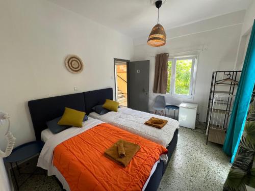 1 dormitorio con 1 cama grande con sábanas de color naranja y almohadas amarillas en Avra Boutique en Benitses