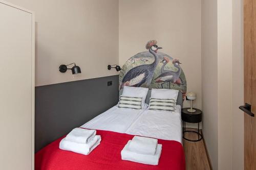 - une chambre avec un grand lit et une couverture rouge dans l'établissement Budget Apartment Gliwice 1min from Main Square, à Gliwice