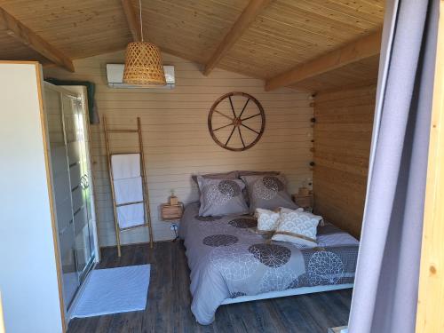 a bedroom with a bed in a wooden cabin at LAlexandrie in Régusse