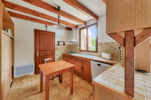 a kitchen with wooden cabinets and a wooden table at Maison pour 8 avec jardin entre Plages et Golfe in Sarzeau
