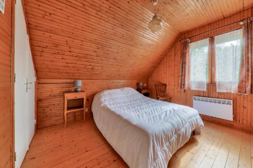 a bedroom with a bed in a wooden room at Maison pour 8 avec jardin entre Plages et Golfe in Sarzeau