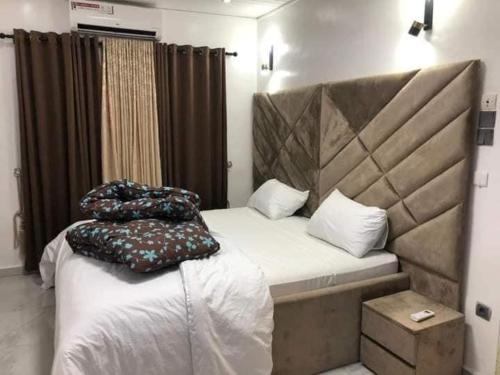 - une chambre avec un lit et 2 oreillers dans l'établissement Villa trois chambres avec piscine, à Cotonou