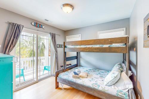 1 dormitorio con 2 literas y ventana en Coastal Cay, en Surf City