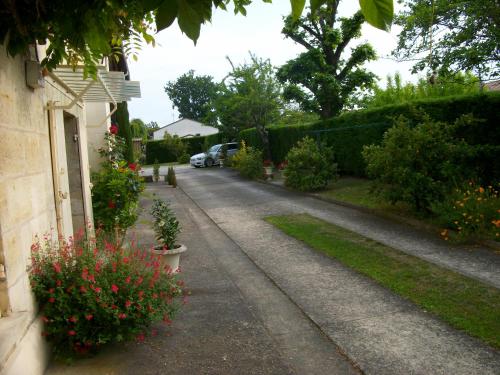 een oprit van een huis met bloemen en planten bij Domaine de Monein in Saint-André-de-Cubzac