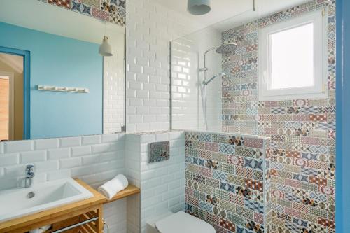 a bathroom with a sink and a mirror at À 200m de la plage de Langoz - Maison pour 10 in Loctudy