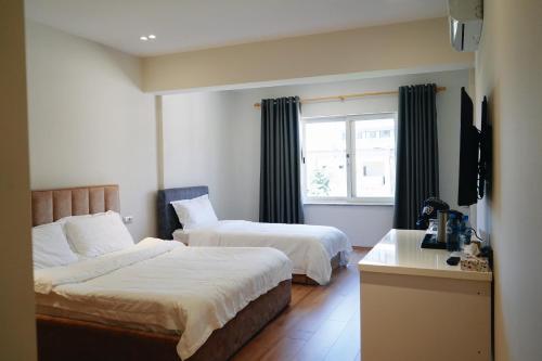 a hotel room with two beds and a window at Ufo Rooms City Center in Tirana
