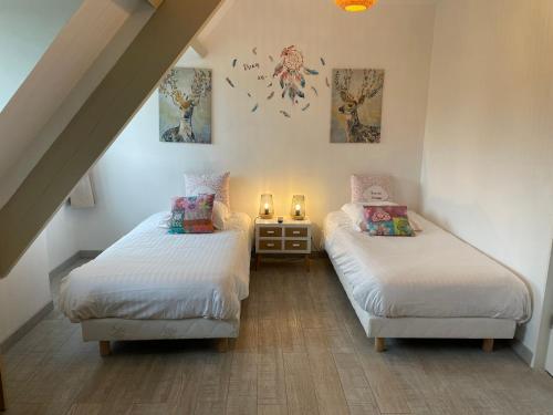 Cette chambre mansardée comprend 2 lits jumeaux et 2 bougies. dans l'établissement Manoir de la Houlette, à Saint-Pierre-du-Vauvray