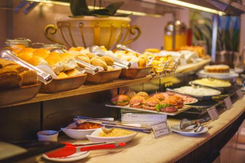 a buffet line with many different types of bread and pastries at Mabu Curitiba Business in Curitiba