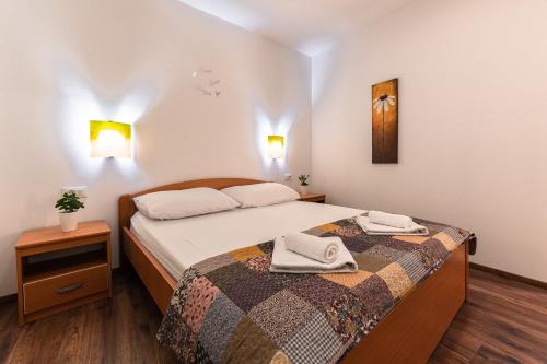 a bedroom with a bed with two towels on it at Villa Old Town in Šibenik