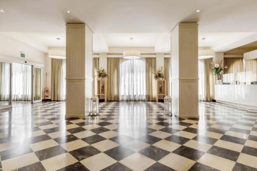a lobby with a black and white checkered floor at Hotel Catalunya in Alghero