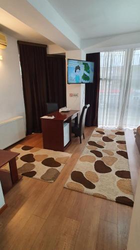 Habitación con escritorio y habitación con alfombra. en Pensiunea Select en Arad